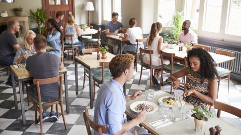 Menschen sitzen mit Abstand in einem Restaurant